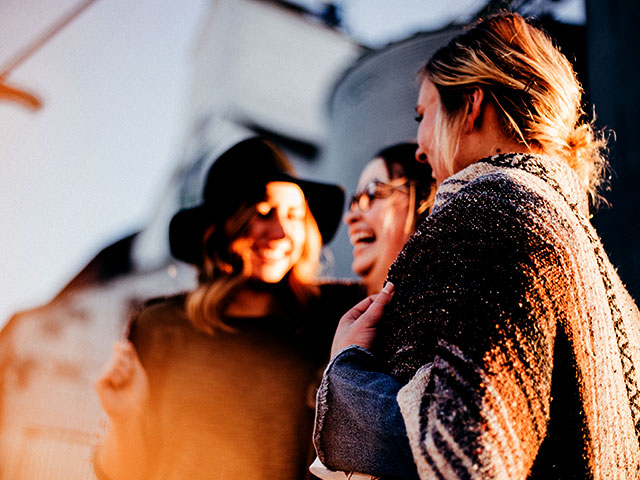 Three women laughing and having fun outside