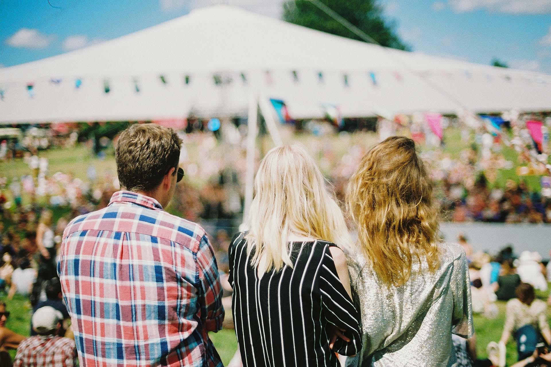 3 people looking at event under a tent