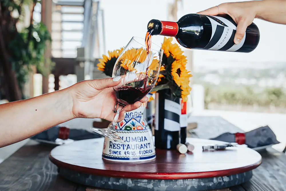 Red wine being poured for a woman